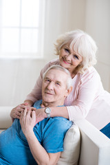 Happy senior couple embracing and relaxing together at home