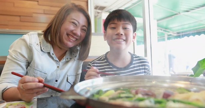 Happy asian family mother and son enjoy eating