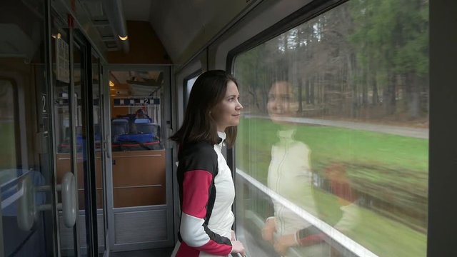 Woman looks out the window in a train and smiles