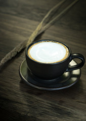 Hot coffee in black cup.