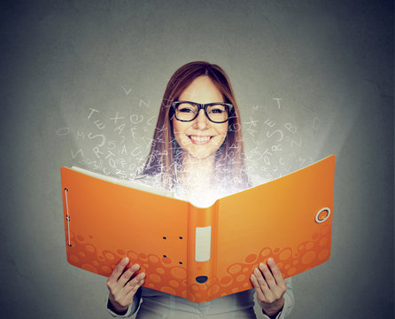 Smiling woman reading a book with letters flying away