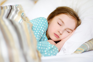 Adorable little girl sleeping in the bed