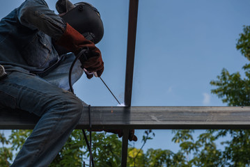 Welding steel by the male worker in industrial metal steel.