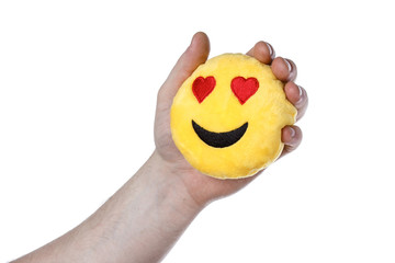 In the hands of a toy smile emoji. Isolated background