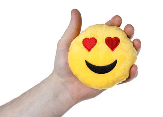 In the hands of a toy smile emoji. Isolated background