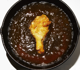 Frying chicken leg in pan 