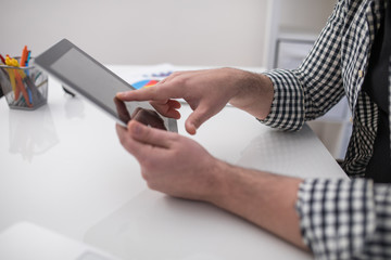 Close up and cropped photo businessman at workplace with tablet pc