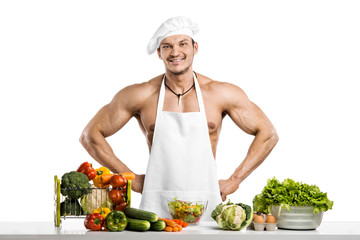 Man bodybuilder in white toque blanche and cook protective apron