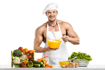 Man bodybuilder in white toque blanche and cook protective apron cooking cottage cheese and vegetables