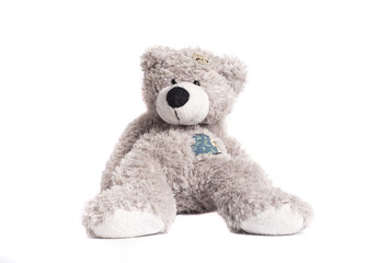 gray teddy bear with a patch on a white background