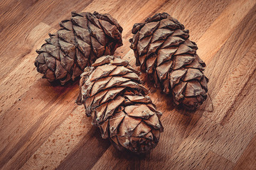 Сосновые большие шишки на деревянной кухонной доске. Плоды хвойного дерева © danysharipova