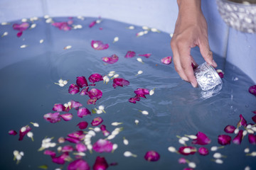 Water in water dipper with colorful flowers pedestal for Songkran festival, Thailand