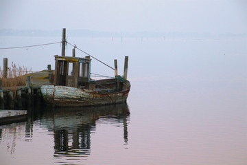 Fototapeta premium Very old fishing boat awaiting scrapping in February