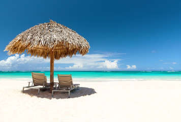 Beach chairs with umbrella and beautiful sand beach in Punta Cana, Dominican Republic