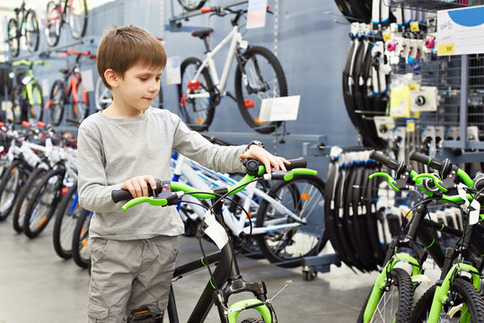 Boy chooses bicycle in sport shop