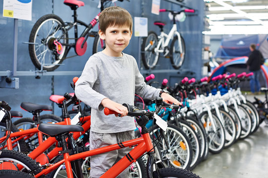 Boy chooses bicycle in sport store