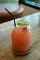 Iced strawberry juice on wooden table.