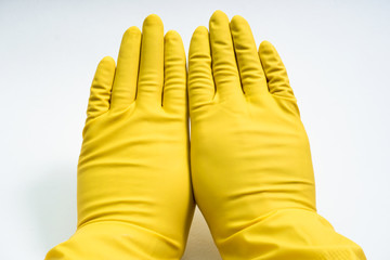 hands in yellow rubber gloves on white background