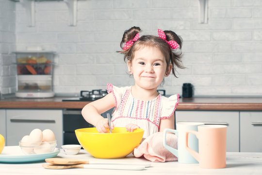 Cute Little Girl Baker On Kitchen With Baking Ingredients