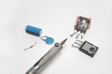 Fragment of soldering iron and several components of electronics
