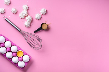 Bakery background frame. Cooking merengues, ingredients - eggs with sugar, over pink background. Spring cooking theme. Top view, copy space.