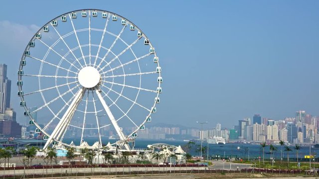 HongKong-04 April, 2017: 4K Observation big ferris wheel and amusement rides in central Hong Kong. Downtown skyline in the background-Dan