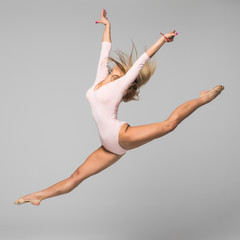 Fototapeta premium Young girl gymnast in pink body isolated on white