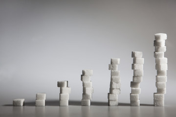 White sugar cubes arranged in increasing columns. Seven diagram towers on the gray background.