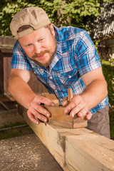Carpenter chipping the wooden plank