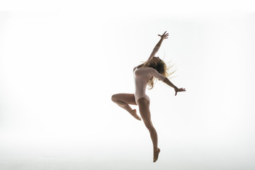 Young slim gymnast in studio on white background