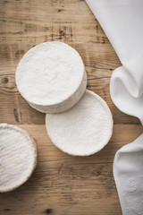 Top view on Camembert cheese on wooden board. Serving French homemade soft cheese. Food concept