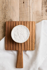 Top view on Camembert cheese on wooden board. Serving French homemade soft cheese. Food concept