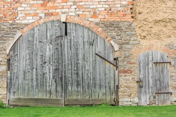 Fototapeta na wymiar Großes Stalltor und Holztür an einem Bauernhof