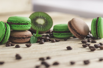 Green and brown french macarons with kiwi, coffee beans and mints decorations
