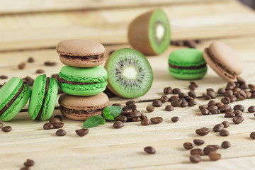 Green and brown french macarons with kiwi, coffee beans and mints decorations