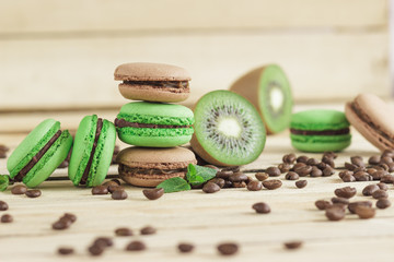 Green and brown french macarons with kiwi, coffee beans and mints decorations