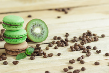 Green and brown french macarons with kiwi, coffee beans and mints decorations