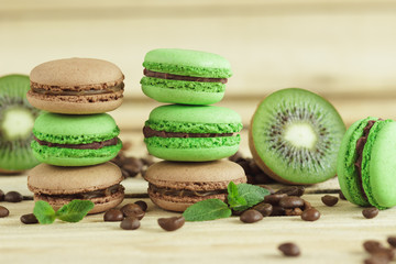 Green and brown french macarons with kiwi, coffee beans and mints decorations