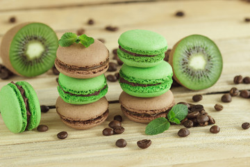 Green and brown french macarons with kiwi, coffee beans and mints decorations