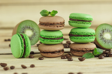 Green and brown french macarons with kiwi, coffee beans and mints decorations