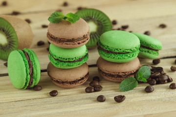 Green and brown french macarons with kiwi, coffee beans and mints decorations