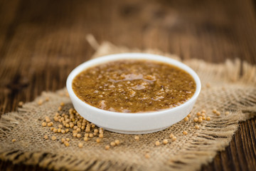 Fresh made Mustard (sweet) on a rustic background