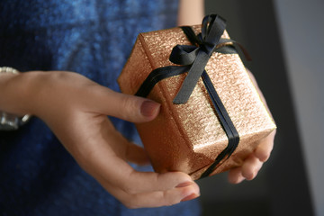 Woman holding gift box in hands, closeup