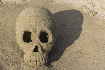 Skull, built of sand, at a beach in Tuscany, Italy