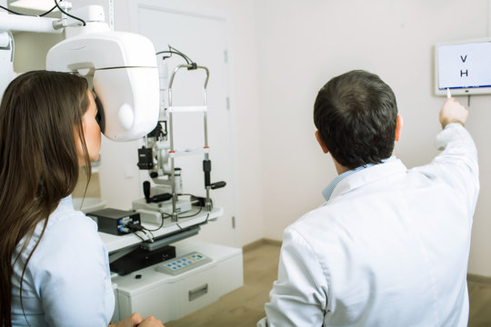 patient woman having her eyes examined by an optometrist using phoropter, in ophthalmology clinic.