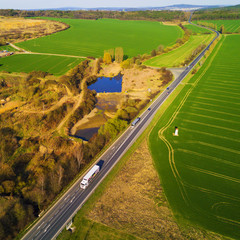 Aerial view of highway going through countryside in hot sunset evening. Landscape aerial...