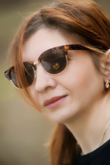 Woman wearing sunglasses and a yellow coat