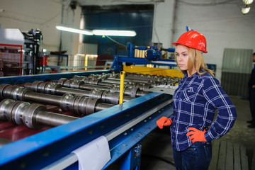 woman in red safety helmet at metal tile roof manufacturing factory