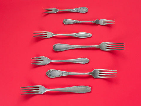 Ancient silver forks collection. On red background