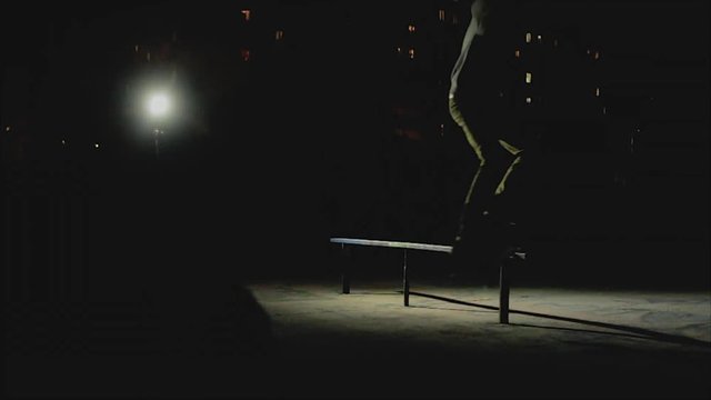 Boy riding on skateboard at night. The skater slides on the rail.